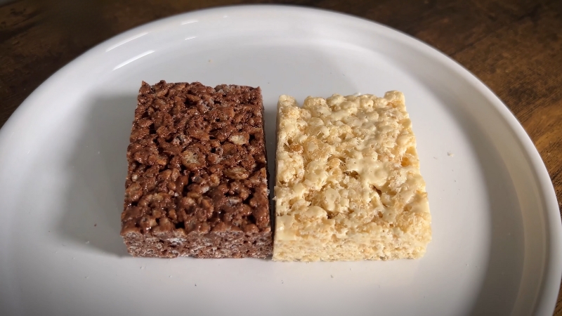 Two Protein Rice Krispie Treats on A White Plate, One Chocolate-Flavored and The Other Classic Vanilla