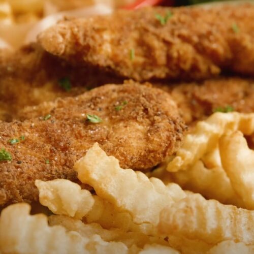 Crispy fried chicken fingers and waffle fries