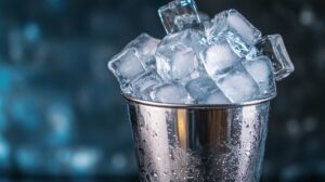 A metal bucket filled with ice cubes, glistening with condensation