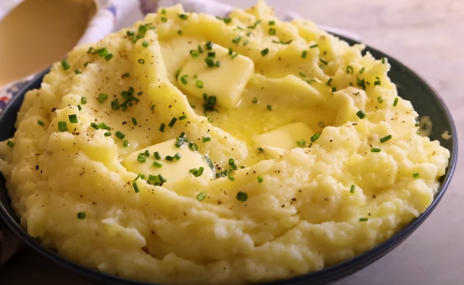 A bowlful of creamy, buttery mashed potatoes, speckled with fresh chives