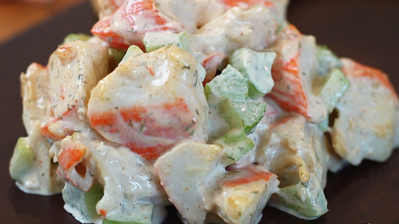 Close-up of creamy crab salad with chopped celery and imitation crab pieces