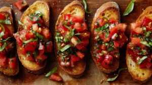 Slices of toasted bread topped with diced tomatoes and fresh basil
