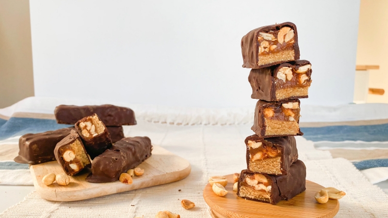 Stacked no-bake vegan Snickers bars with peanuts and chocolate
