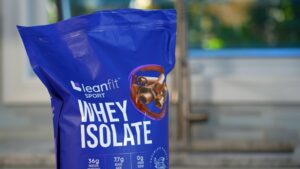 A bag of Leanfit Sport Whey Isolate protein powder in chocolate flavor is shown on a counter
