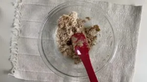 Almond flour mixture with a red spatula in a glass bowl