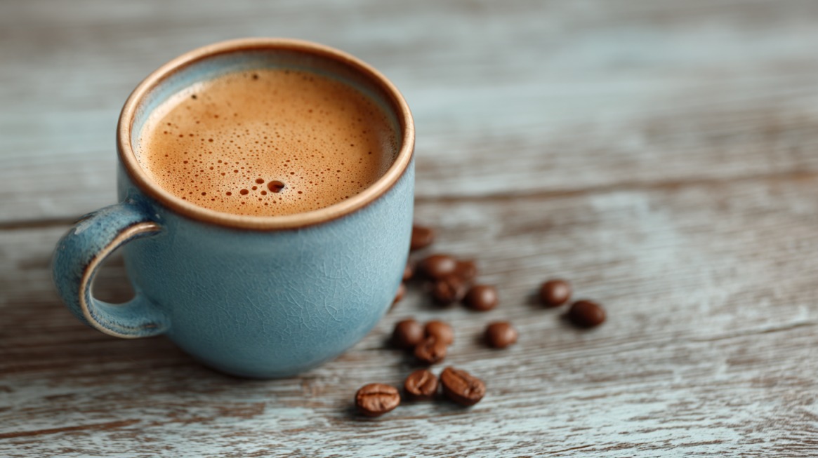 Cup of coffee with coffee beans on a wooden table