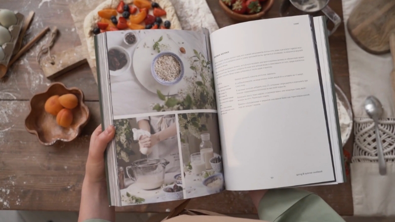 Open cookbook spread with recipes and food photos on a wooden table
