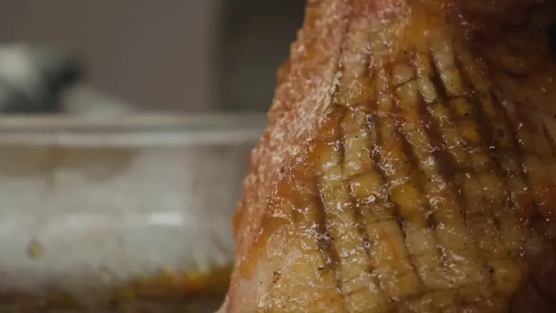 Glazed butt portion ham near the end of reheatin with caramelized surface detail