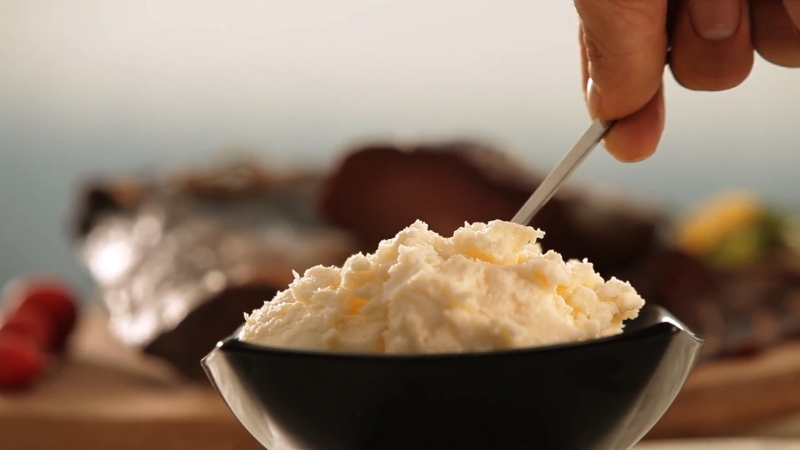 Fresh kajmak served in a black bowl at Kajmak & More in Belgrade