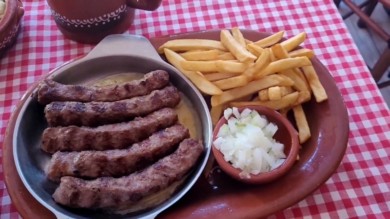 Grilled sausages with fries and chopped onions served at Restaurant Zavičaj in Belgrade