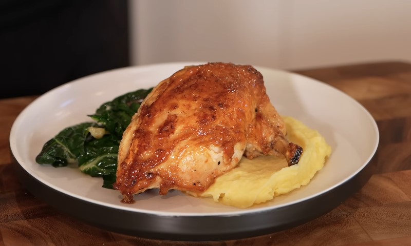 A roasted chicken breast on creamy mashed potatoes