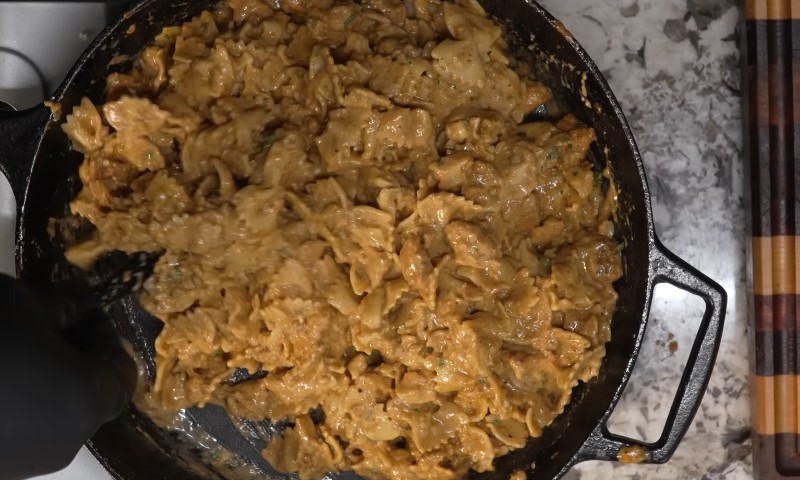 A close-up of a cast-iron skillet filled with golden brown cooked chicken marinated in a creamy sauce