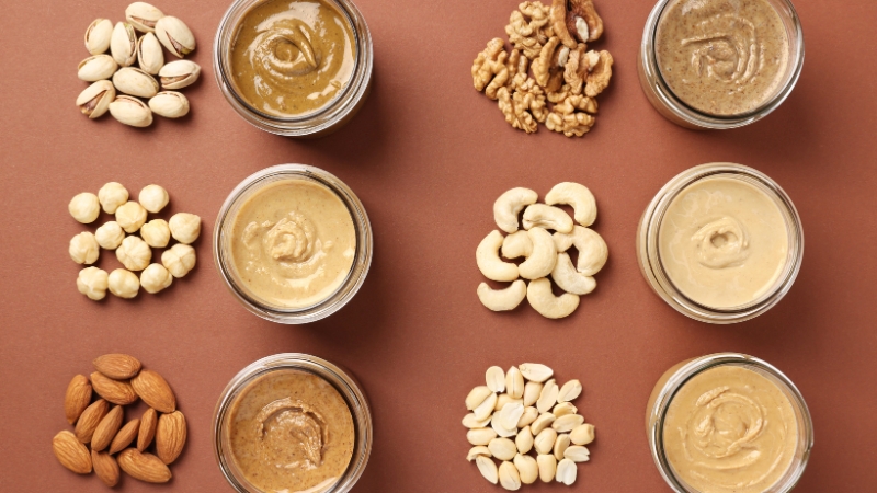 Different nuts and nut butters arranged in small bowls on a table