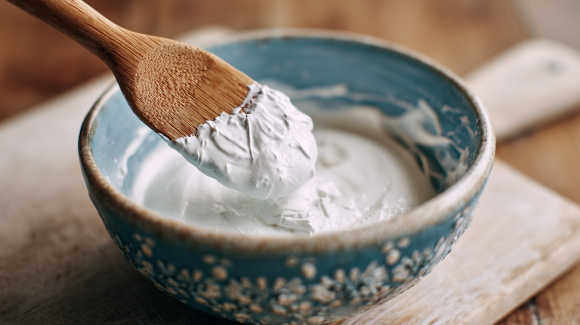 Thick white mixture in a bowl with a wooden spoon