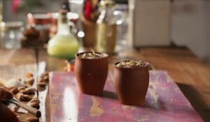 Chocolate phirni served in clay cups and topped with pistachios, almonds, and grated chocolate